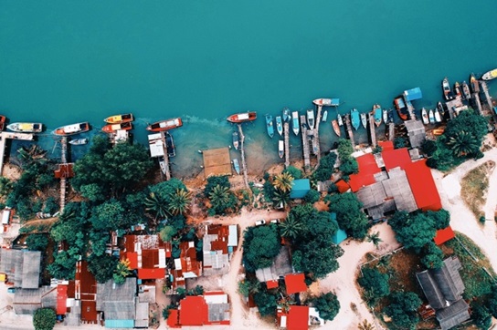 Aerial view of waterfront homes with many jet skis and boats.